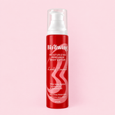 A 200 ml pump bottle of Birdwing 'Lovely Coconut' moisturizing and perfumed body lotion, featuring a vibrant red body with white text and a white pump dispenser, set against a solid light pink background.